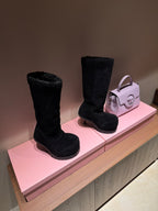 Black suede knee-high boots with chunky tread sole