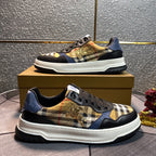 Burberry low-top sneakers on box step with black uppers, plaid patch, gold emblem, white sole