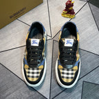 Burberry low-top sneakers with black uppers, navy check panel, gold accents, white sole