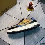 Burberry low-top sneaker side view with plaid upper, gold graphic, white sole, black outsole edge