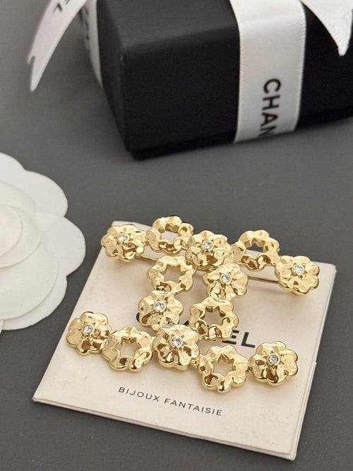 Chanel gold-tone statement brooch with floral charms on card, gift box shown