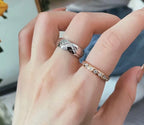 Silver tone band ring and rhinestone detail on finger, with another ring style
