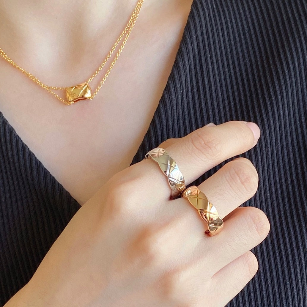Gold tone textured band ring on finger with matching necklace