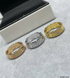 Chanel accessories: gold and silver-tone rings displayed on textured surface