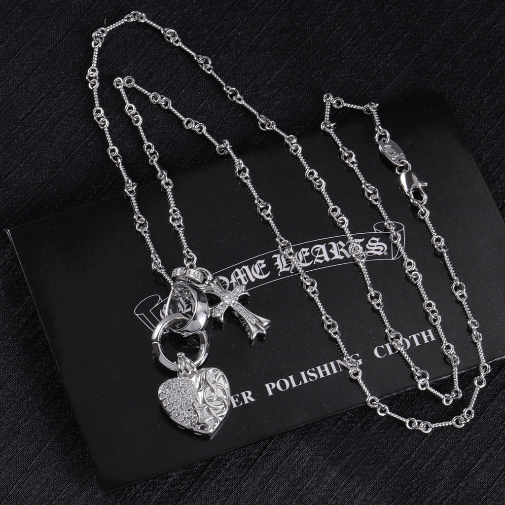 Heart locket and cross charm necklace set on display card, silver tone