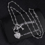 Heart locket and cross charm necklace set on display card, silver tone