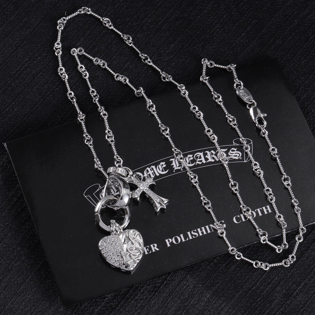 Heart locket and cross charm necklace set on display card, silver tone