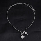 Single heart locket and cross pendant necklace with linked chain, silver tone