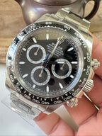 Steel chronograph watch with dark dial, three subdials and gold-tone bezel accents