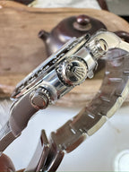 Steel chronograph watch with crown and pushers on the case