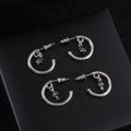 Silver hoop earrings with star charm and stud backing, circular silhouette