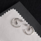 Silver hoop earrings with star charms and back posts on light card