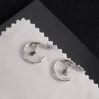 Silver hoop earrings with star charms and back posts, closeangled view