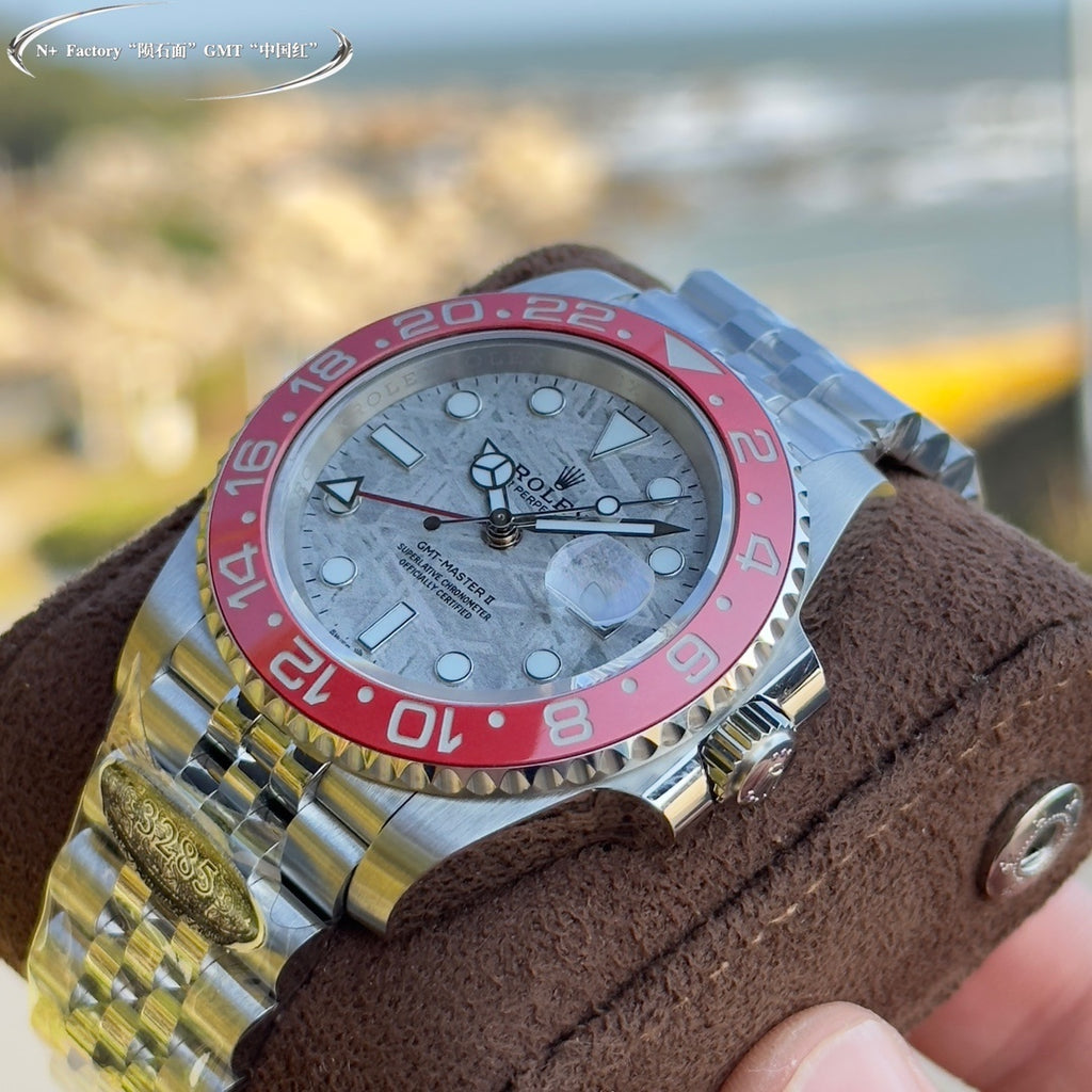Rolex GMT-Master watch close-up, steel case, light dial, pink-red bezel, markers