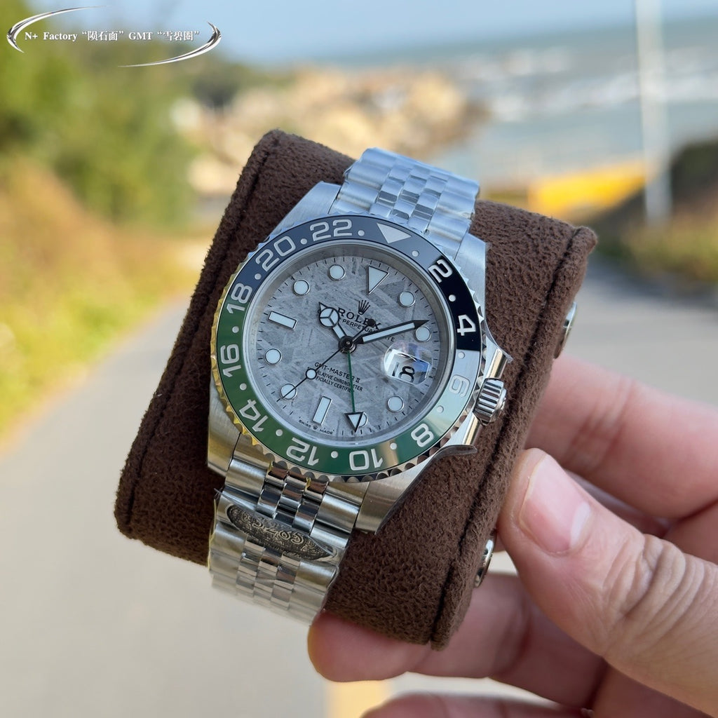 Rolex watch with steel bracelet, grey dial, blue and green bezel on brown strap