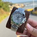 Rolex watch with steel bracelet, grey dial, blue and green bezel on brown strap