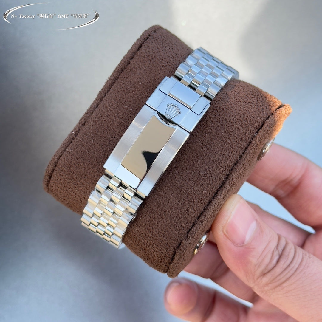 Rolex watch clasp and links on brown strap, polished steel bracelet