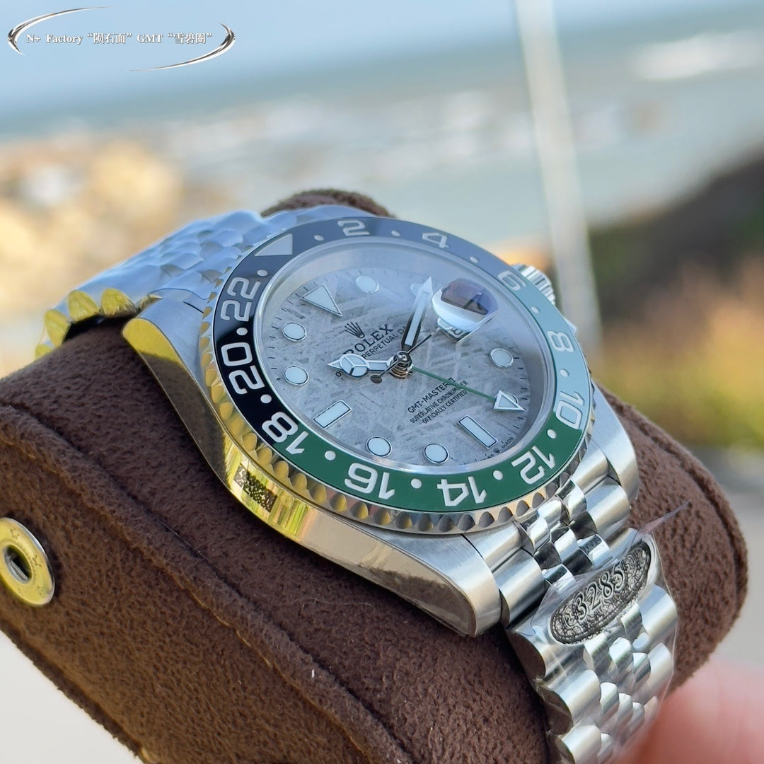 Rolex watch side angle, grey dial, blue and green bezel, steel bracelet on brown strap