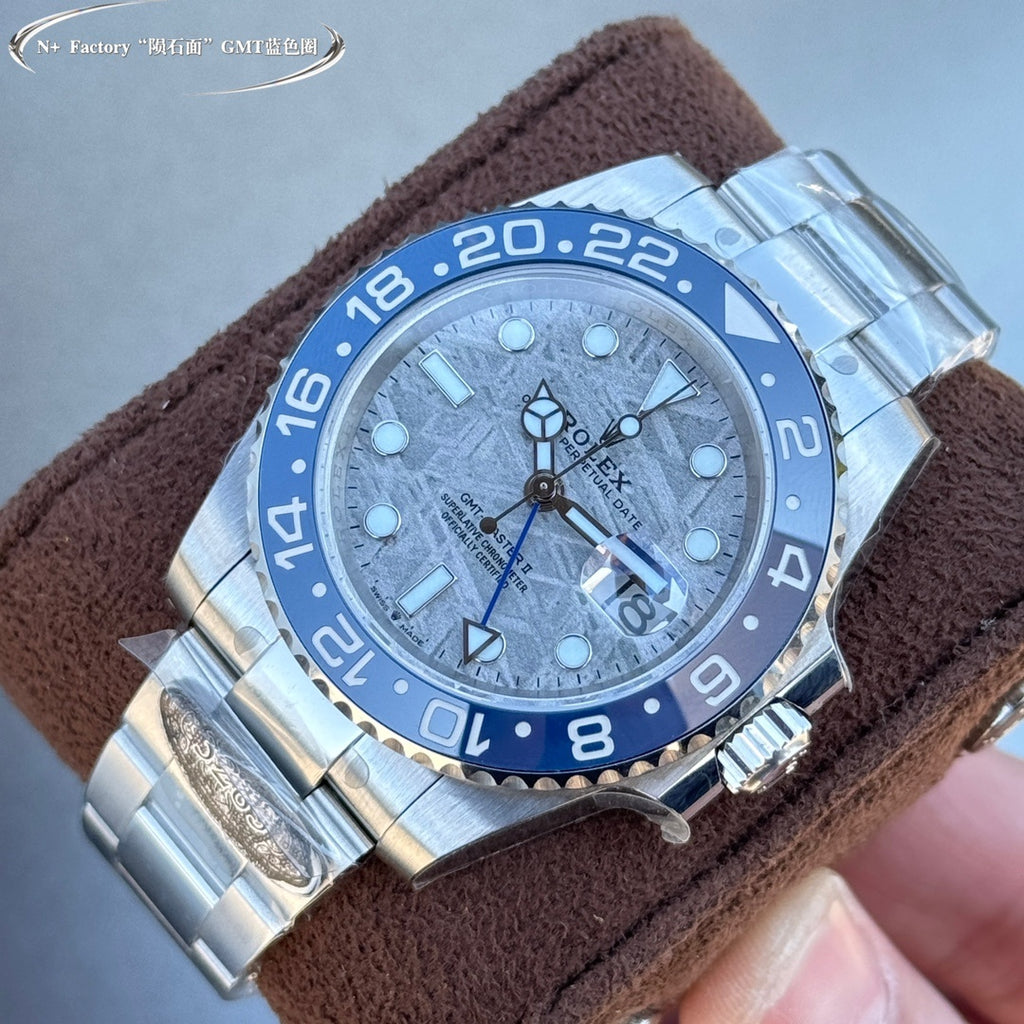 Rolex GMT-style watch with blue bezel, blue textured dial, steel bracelet on brown strap