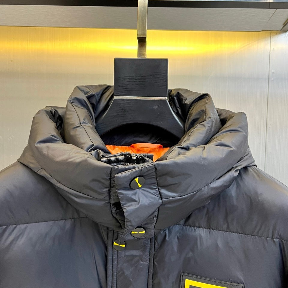 Dark puffer jacket hood opening with orange inner lining and front button detail