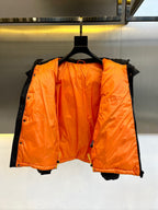 Dark puffer jacket with orange inner lining, shown open on a hanger