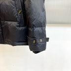 Dark puffer jacket sleeve with adjustable cuff strap and snap button