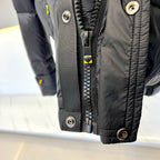 Dark puffer jacket front with zipper placket, snaps, and yellow pull tab
