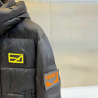 Dark puffer jacket shoulder with yellow logo patch and FENDI side label