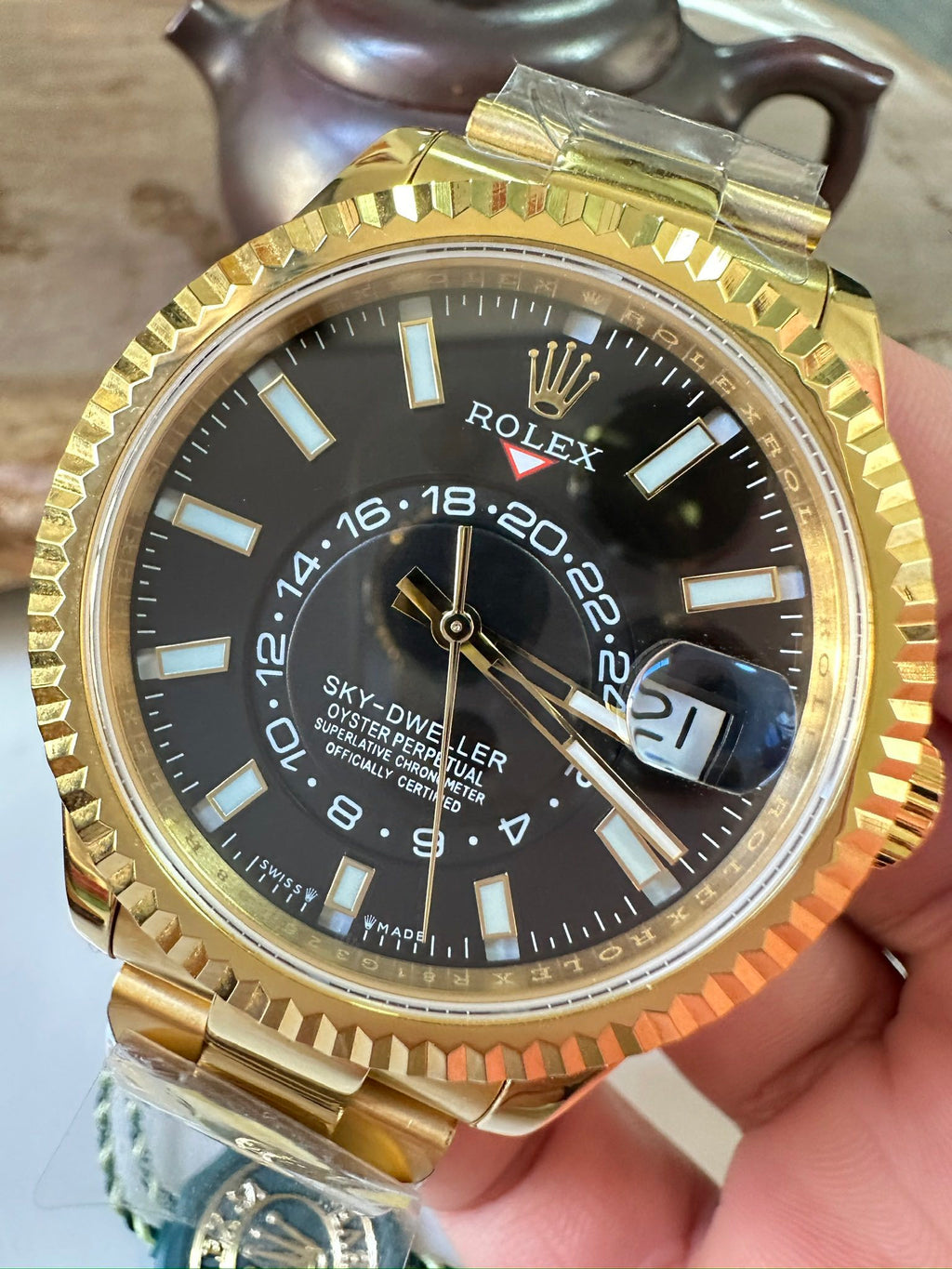 Rolex Sky-Dweller watch with black dial, gold-tone bezel and luminous markers