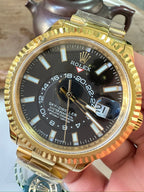 Rolex Sky-Dweller watch with black dial, gold-tone bezel and luminous markers