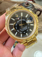 Rolex Sky-Dweller watch with black dial and gold-tone bracelet, round bezel