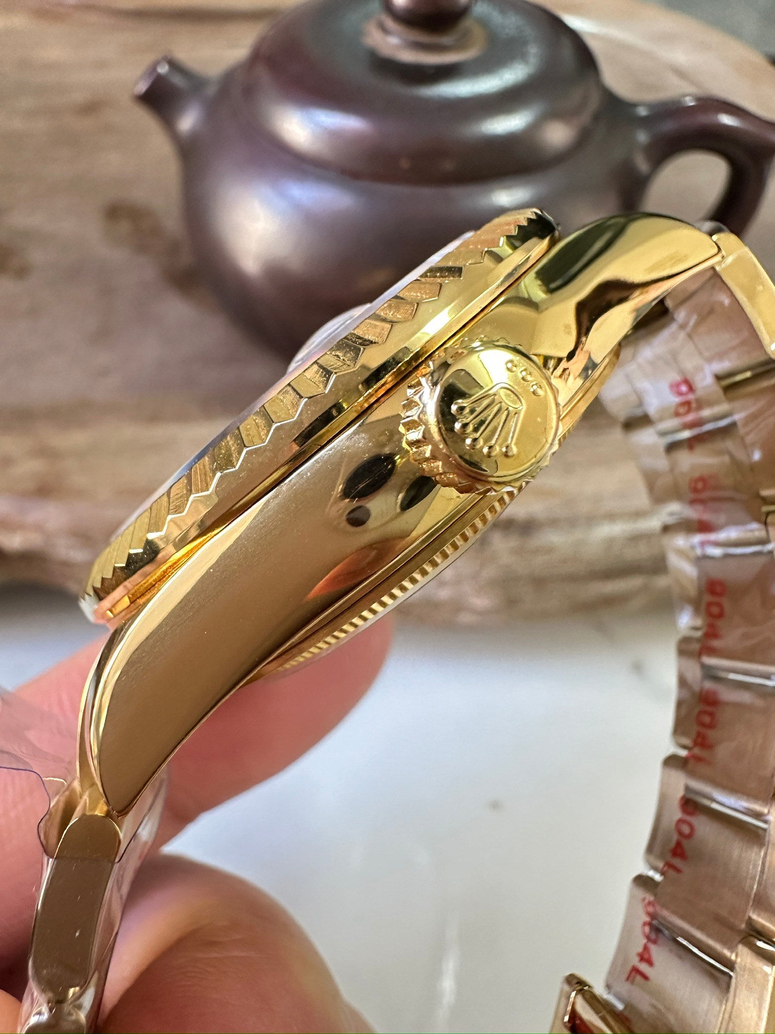 Rolex Sky-Dweller watch case side in gold-tone with crown emblem