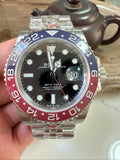 Rolex GMT watch with black dial, blue/red bezel, metal bracelet and date window