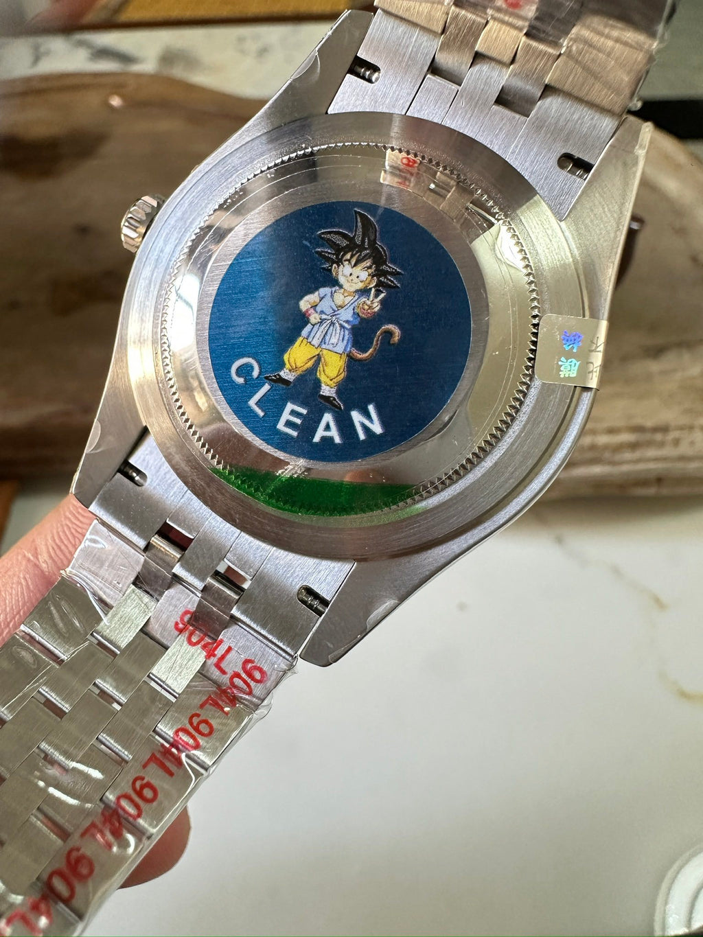 Stainless steel watch caseback with blue CLEAN graphic and engraved numbers