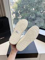 Outsoles of white low-top sneakers with grid tread and embossed logo pattern