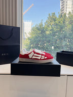 Red Amiri low-top sneaker on box, white laces and strap-style side panel