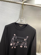 Black long-sleeve T-shirt close-up with Versace logo and charm print