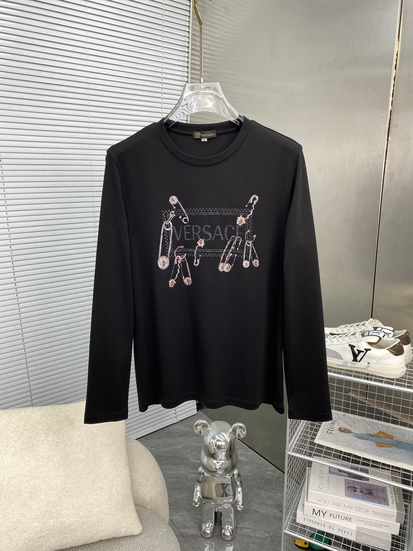 Black long-sleeve T-shirt with Versace logo and dangling charm graphic
