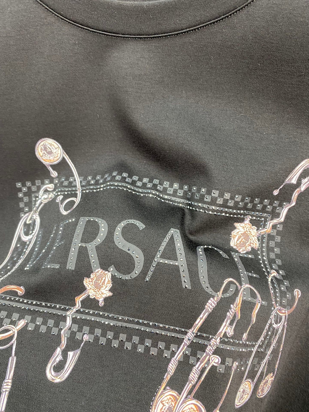 Black long-sleeve T-shirt chest graphic with Versace logo and charms