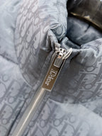Long puffer jacket zipper pull close-up with Dior tag on gray-blue lining