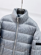 Long puffer jacket close-up with gray-blue Dior monogram, hood, and zipper