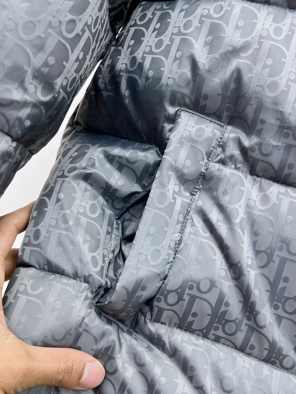 Long puffer jacket quilted panels close-up with gray-blue Dior monogram pattern