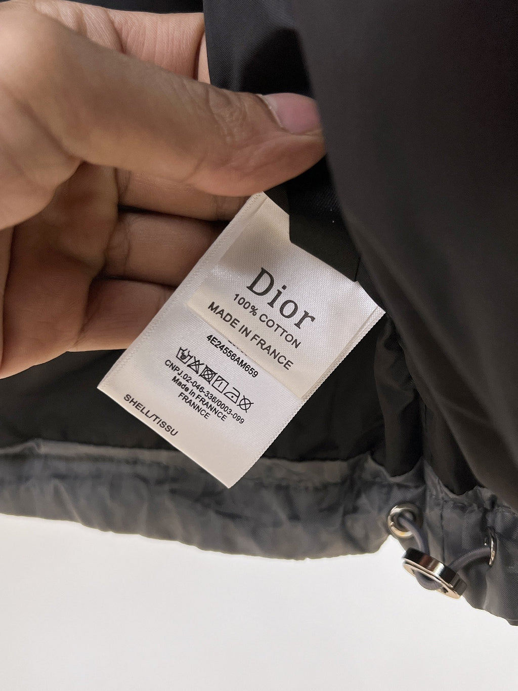 Dior puffer jacket interior care tag with text and “Made in France” marking