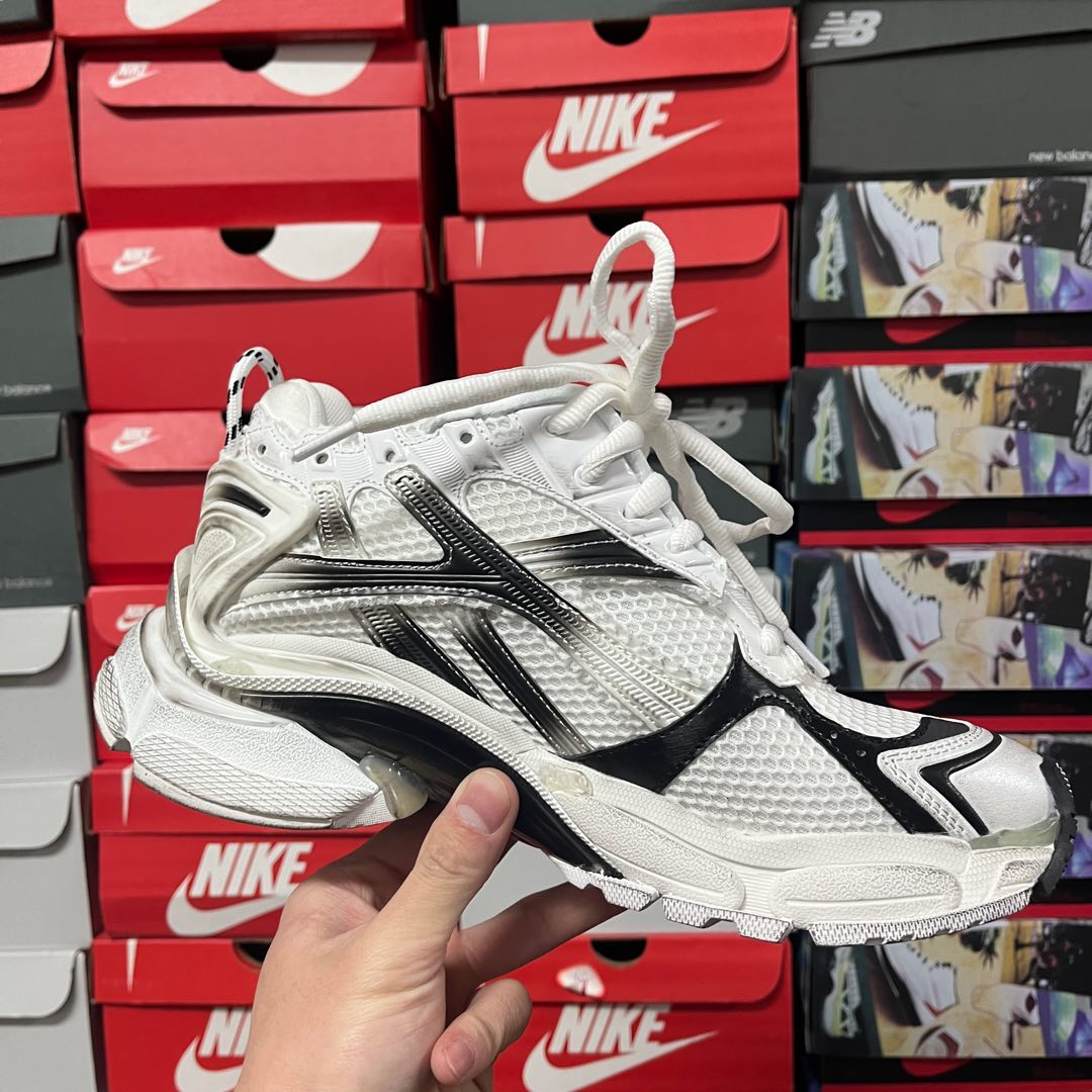 Unisex white lace-up sneaker angled view with black side stripes and chunky sole