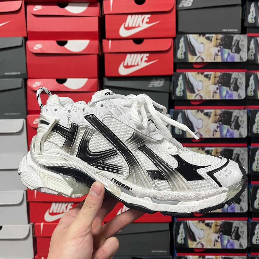 Unisex white lace-up sneakers with black logo stripes and chunky sole