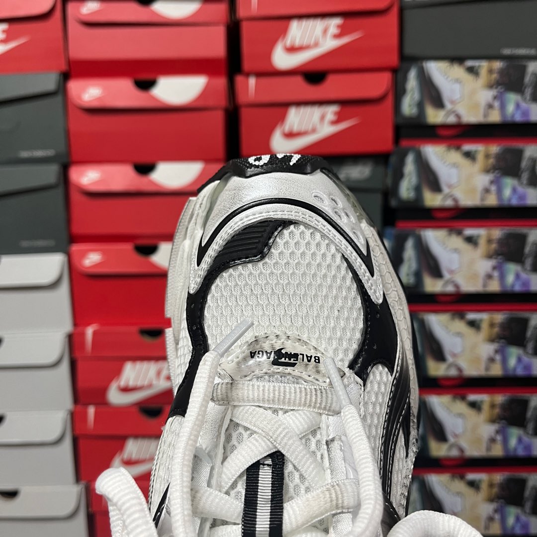 Unisex white sneaker with mesh upper, padded collar, and black heel detailing