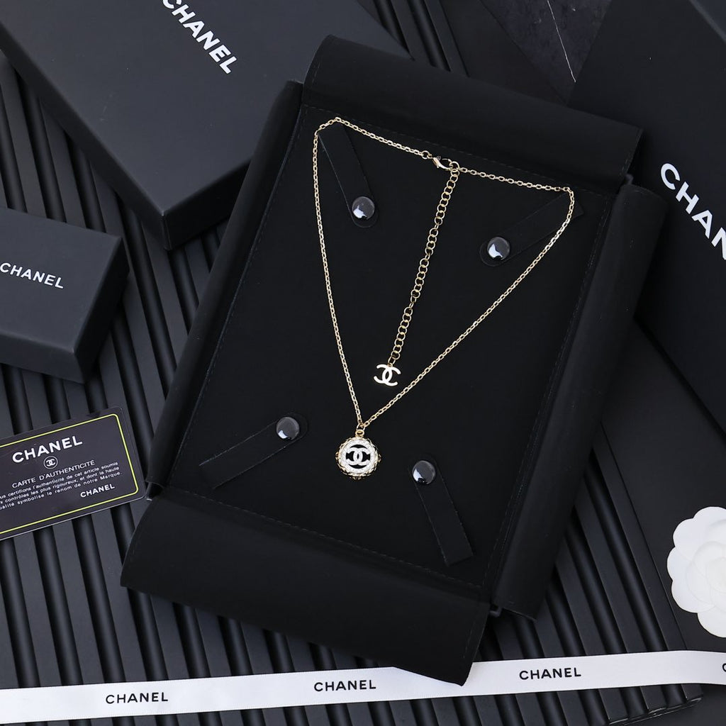 Gold-tone Chanel pendant necklace on black card, round CC charm and chain
