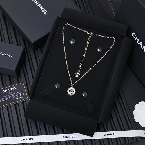 Gold-tone Chanel pendant necklace on black card, round CC charm and chain
