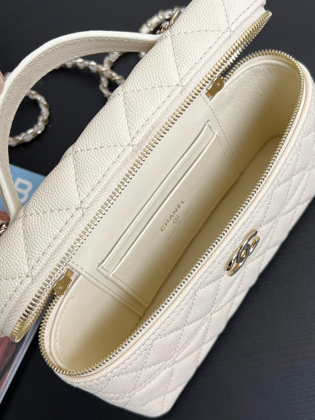 Chanel mini bag interior view, cream lining, gold zipper and hardware