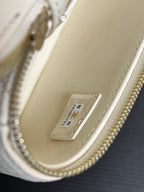 Chanel authenticity tag on cream leather interior, gold zipper edge and chain
